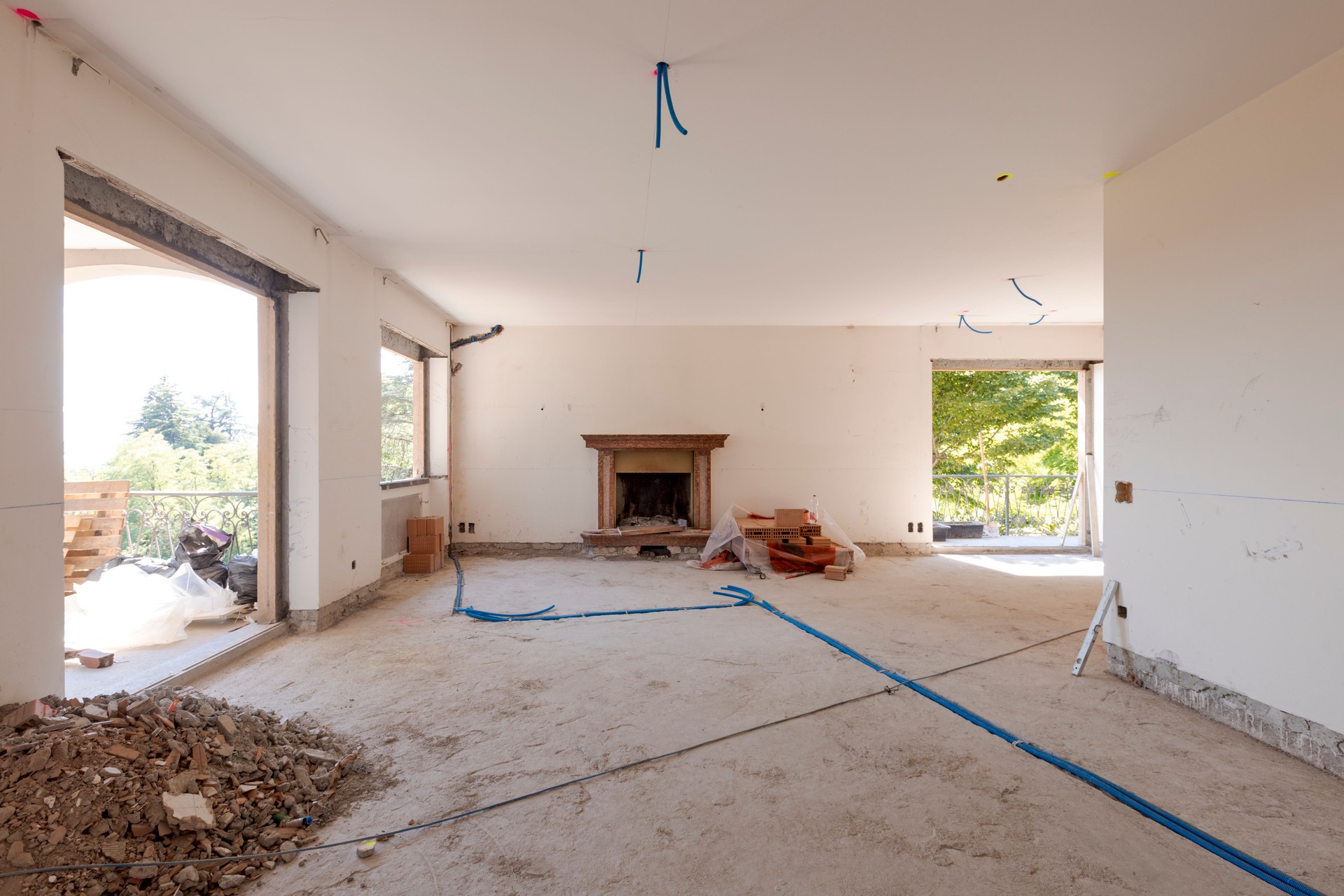 Large bright room with windows of an ancient villa undergoing renovation. The old walls have been torn down and new ones have been created